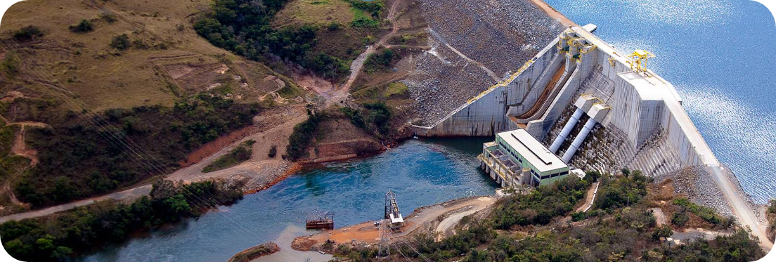 Foto aérea mostra vertedouro da usina hidrelétrica Serra do Facão, entre os municípios de Davinópolis e Catalão, no estado de Goiás. No alto, à direita, está o espelho d’água. À direita esquerda, está o curso do rio circundado por vegetação rasteira verde. Fim da descrição.